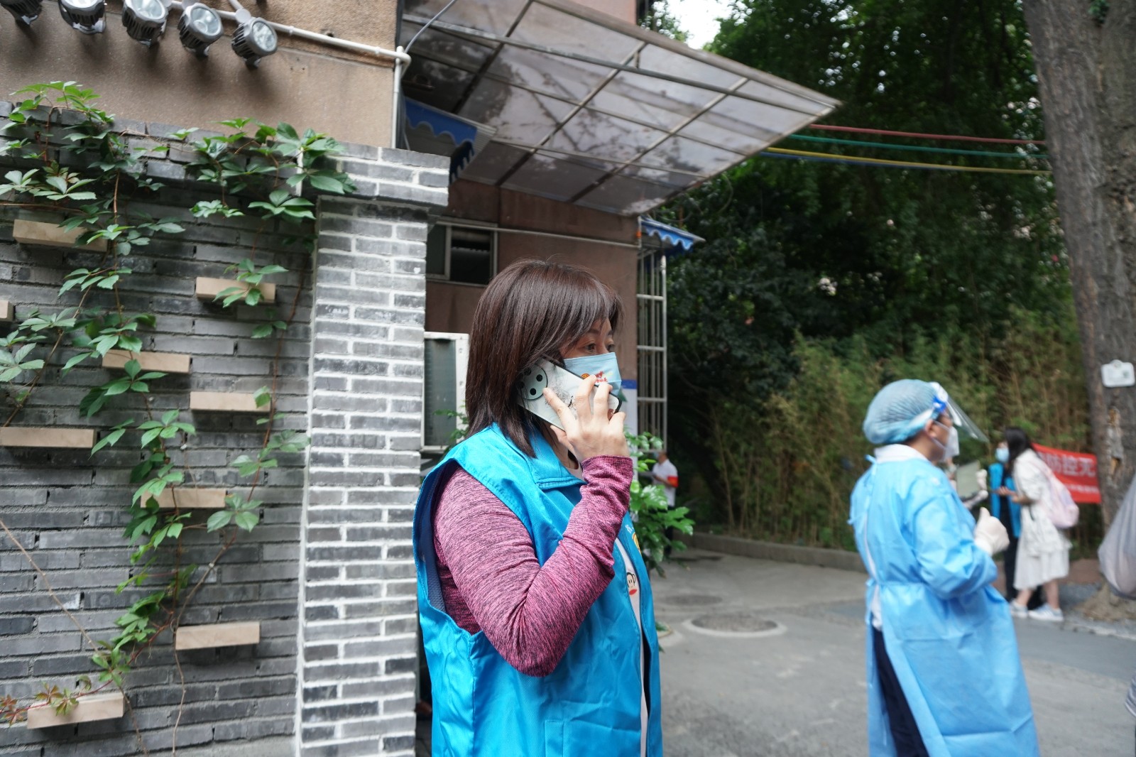 女工部李双正在电话联络社区工作人员，解答居民的问题。.jpg